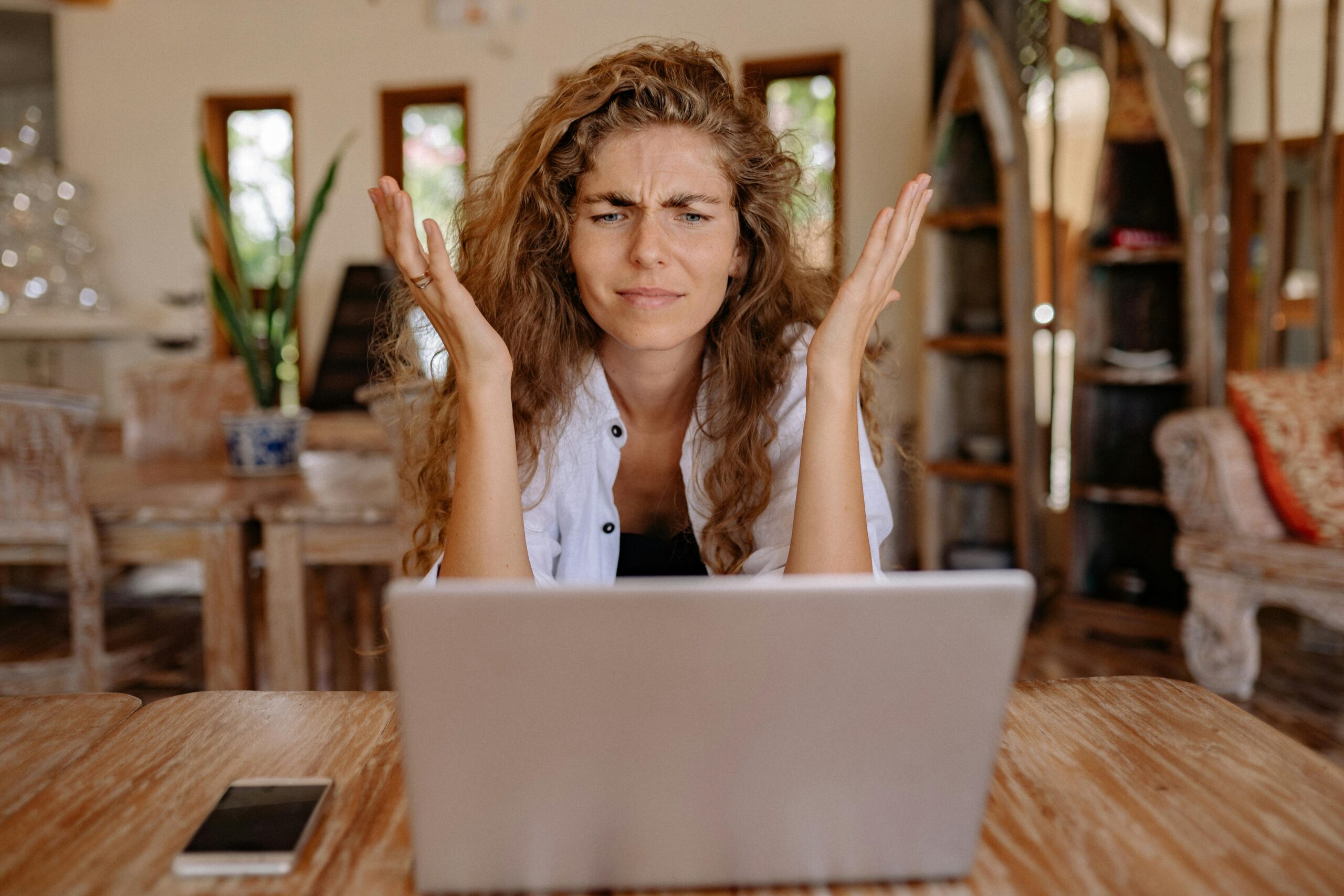 Woman looking at laptop screen and frustrated.